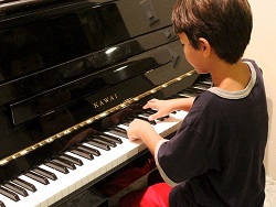un enfant devant son clavier de piano